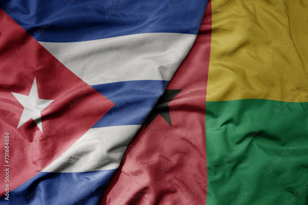 big waving national colorful flag of guinea bissau and national flag of cuba .
