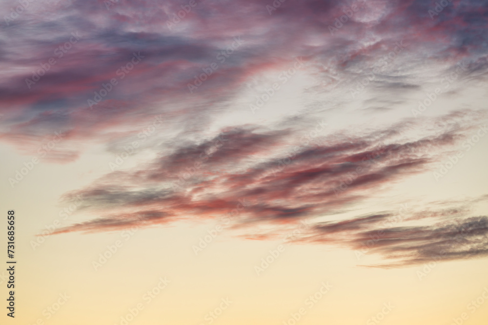 Fototapeta premium A beautiful sky tinted by the sun leaving vibrant shades of gold, pink, blue and multicolored. Clouds in the twilight evening and morning sky. Cloudy sky background in the evening and during the day.