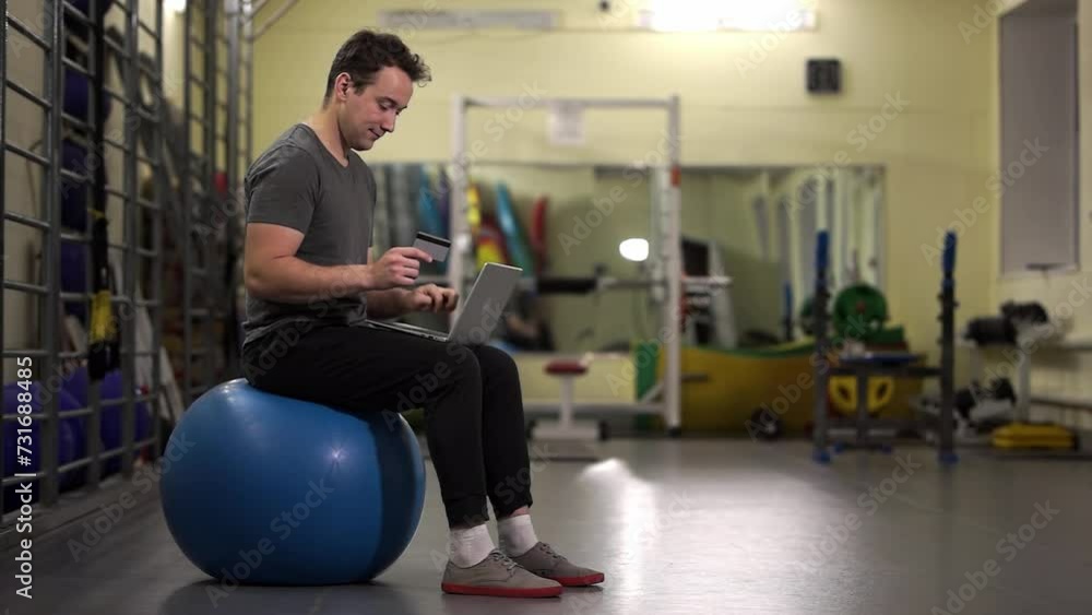 bank card. enters data from a bank card. a man sits on a fitness ball.High-quality footage in 4K format bank card. enters data from a bank card. a man sits on a fitness ball.High-quality footage in 4K format