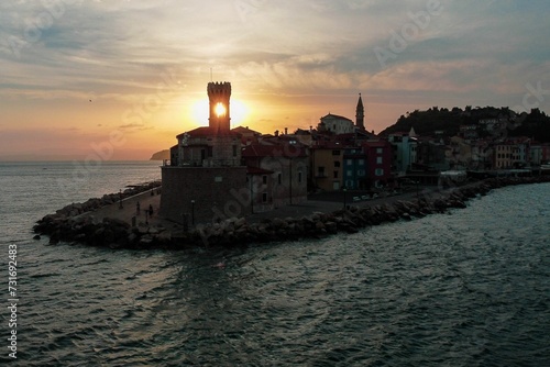 Wallpaper Mural Drone shot of a coastal city's buildings line by the sea under cloudy sky at sunset Torontodigital.ca