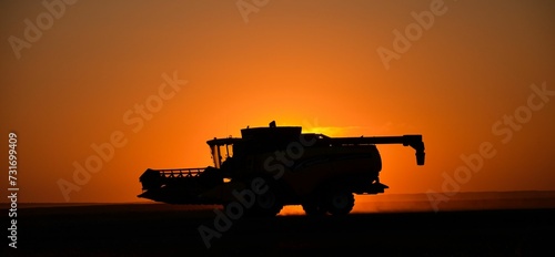 the silhouette of a tractor is driving through the sunset at sunset