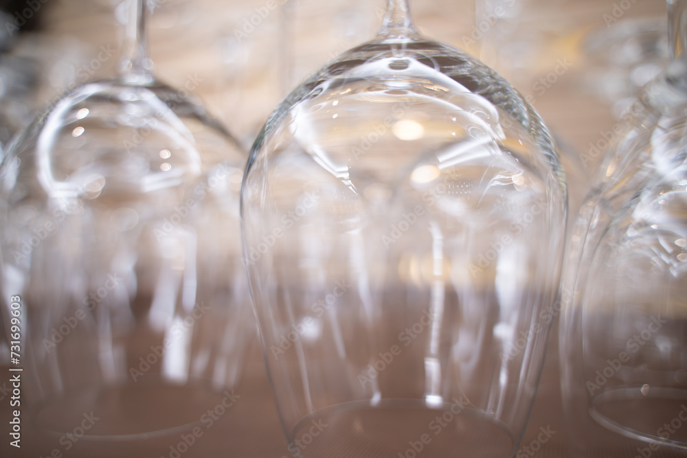 Close-up of wine glasses hanging in a holder in a bar. Apply light and blur effects Close-up of wine glasses hanging in a holder in a bar. Apply light and blur effects