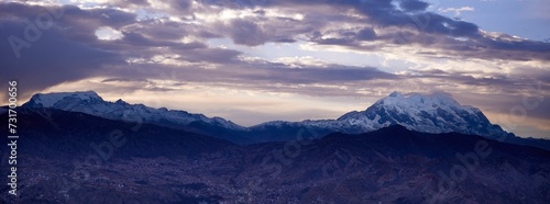 View of snow-capped Illimani mountain with clouds floating above its peak at sunset. Bolivia.