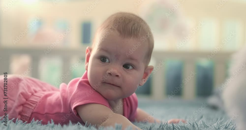 Newborn baby lying on stomach in bright sunny room. Healthy adorable girl in pink clothes looking around at home indoor. Cute infant child smiling. Happy family moment. Sweet childcare lifestyle video Newborn baby lying on stomach in bright sunny room. Healthy adorable girl in pink clothes looking around at home indoor. Cute infant child smiling. Happy family moment. Sweet childcare lifestyle video
