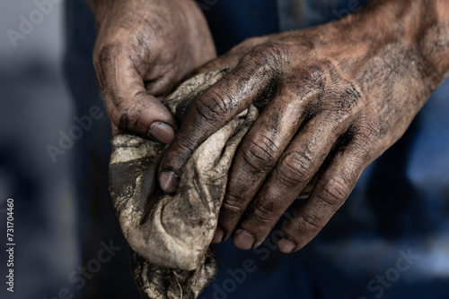 Dirty male hands with a towel after car repair close-up.