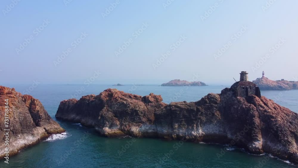 Aerial video of a lighthouse on the rocky mountains surrounded by the sea Aerial video of a lighthouse on the rocky mountains surrounded by the sea
