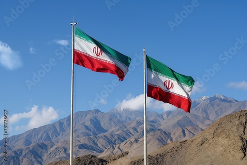 Two iranian flags fly side by side against the backdrop of majestic mountains.