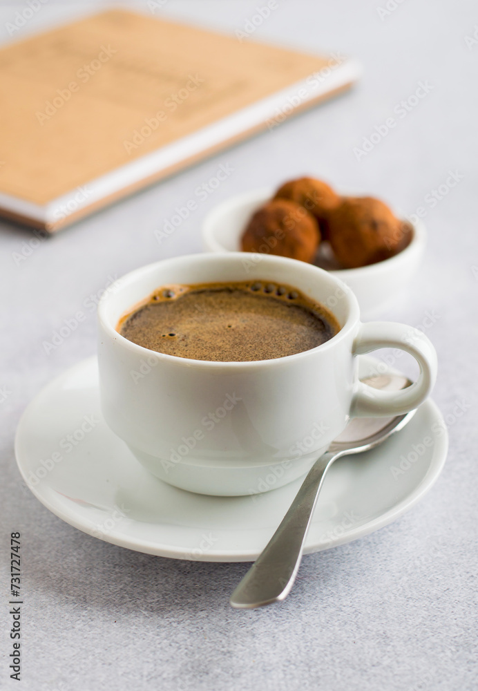 A cup of coffee, truffle sweets and a notepad for notes. Morning ritual. A cup of coffee, truffle sweets and a notepad for notes. Morning ritual.