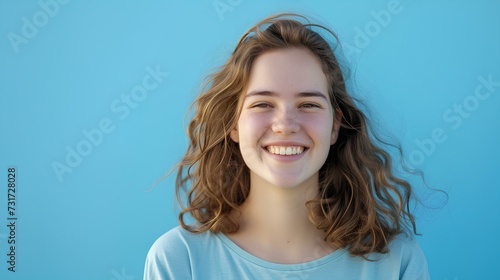 A young woman in front of a sky blue background is smiling awkwardly. current situation is unfortunate, but the concept of hope that it will go well in the future. generative AI