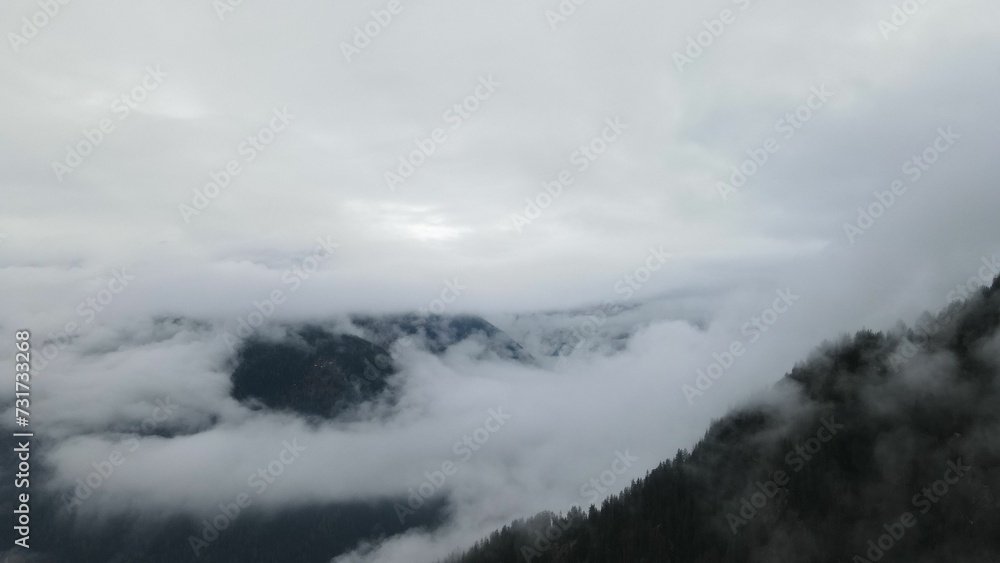 a view looking across the clouds over mountains on a cloudy day a view looking across the clouds over mountains on a cloudy day