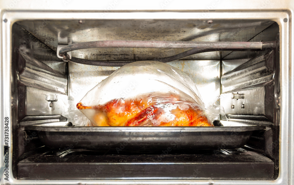 baked duck in a vacuum bag for baking in an old electric oven close-up baked duck in a vacuum bag for baking in an old electric oven close-up