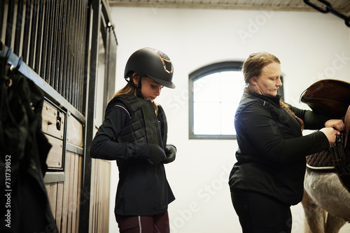 Girl in stables preparing herself for ride