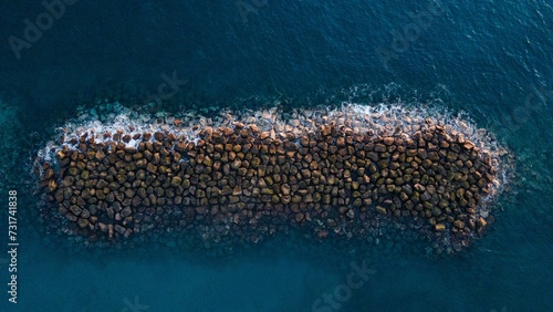 Aerial view of the breakwater in a tranquil blue water photo