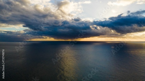 Beautiful ocean landscape with a clear sky and  fluffy clouds illuminated by a bright and warm sun