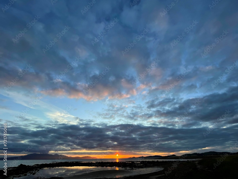 Fototapeta premium Breathtaking and dramatic sunset over a serene sea landscape
