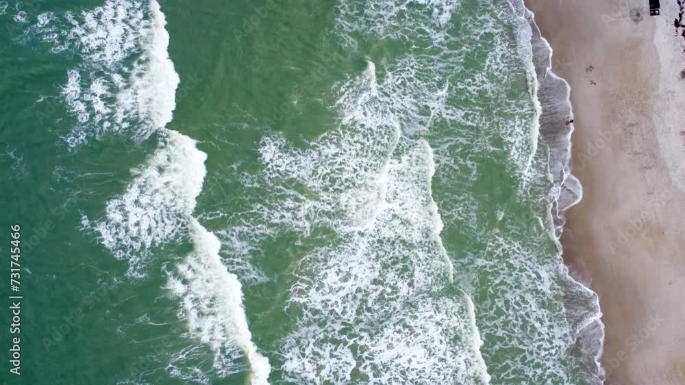 Drone view over sea waves covering a sandy coastline Drone view over sea waves covering a sandy coastline