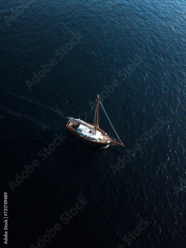 Sailboat peacefully gliding across the vast dark blue ocean