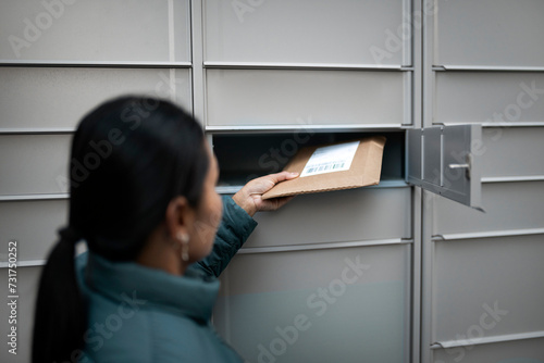 Woman removing package from mail locker photo