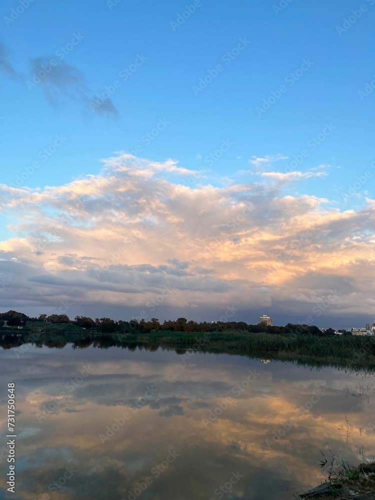 Fototapeta premium a scenic scene with a river in the foreground and large clouds in the sky