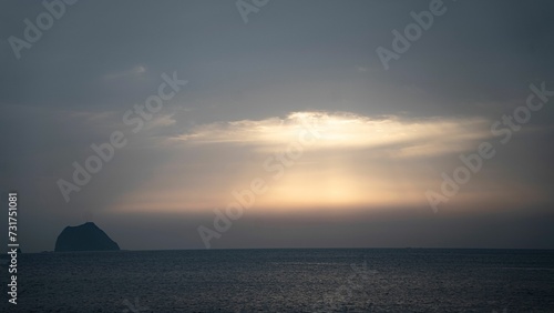 the sun shines through clouds over the ocean and a beach