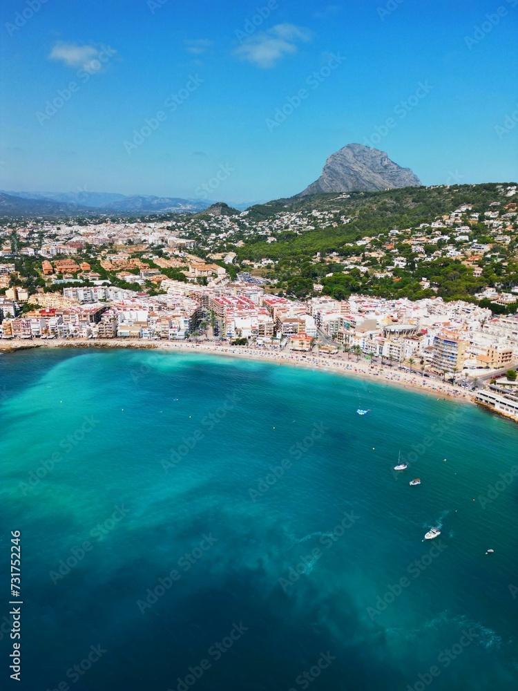 Tranquil beach with several small boats bobbing lazily in the water on Javea Port