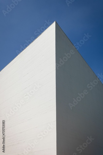 Exterior shot of a modern white building in a vibrant cityscape  set against a brilliant blue sky