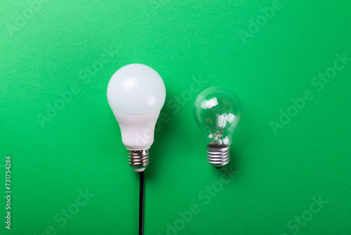 incandescent lamp and led lamp against on isolated green background. Energy efficiency concept. Flat lay. Concept ecology, save planet earth, idea, save energy, economy, saving. Earth day..