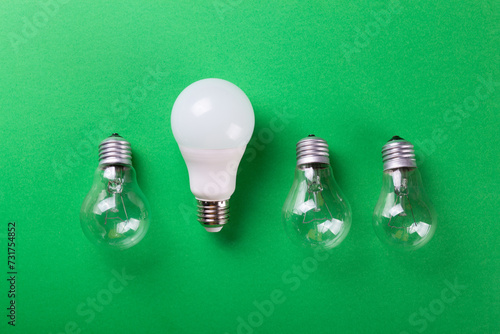 incandescent lamp and led lamp against on isolated green background. Energy efficiency concept. Flat lay. Concept ecology, save planet earth, idea, save energy, economy, saving. Earth day..