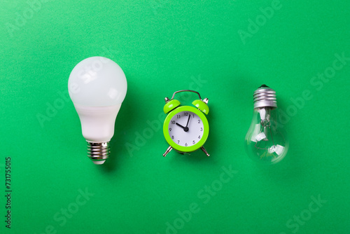 incandescent lamp and led lamps against on isolated green background. Energy efficiency concept. Flat lay. Concept ecology, save planet earth, idea, save energy, economy, saving. Earth day.. photo