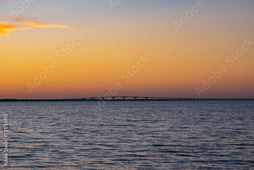 Stunning sunset view over a body of water © Wirestock