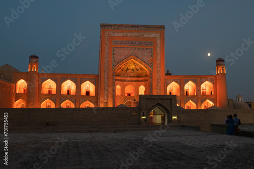 The ancient Allakuli Khan madrasah in orange illumination on the late evening, Khiva photo