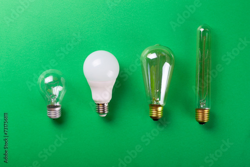 A set of different types of LED lamps isolated on a green background. Selective focus, noise. Energy-saving lamps.