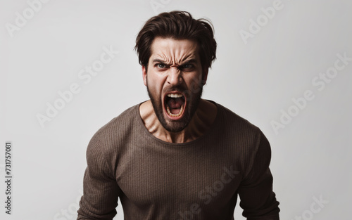 Portrait of a man who is screaming furiously, his face expresses anger and anger, his mouth and eyes are wide open. photo