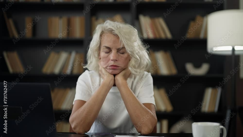 Mature woman suffer headache at work. Senior female has migraine sitting at table at home office rubbing temples. Tired exhausted woman feeling pain fatigue. Menopause symptoms chronic stress.