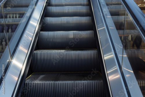 closeup of escalator steps with reflections on polished metal sides