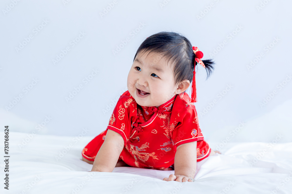 Chinese New Year concept, cute happy little girl in Chinese dress sitting in white living room. Cute Asian baby sitting in white living room, Chinese New Year concept. Chinese New Year concept, cute happy little girl in Chinese dress sitting in white living room. Cute Asian baby sitting in white living room, Chinese New Year concept.