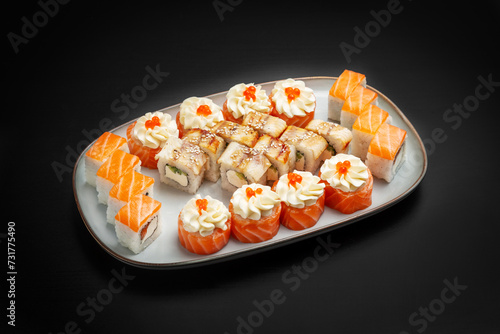 Sushi set, rolls, assorted Philadelphia, unagi with caviar, cheese, salmon. On a black background.