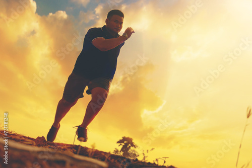 Silhouette of overweight man running sprinting on road. Fat man runner jogging at outdoor workout. Exercise concept for weight control.