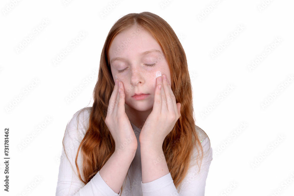 Redhead little girl with freckles uses face cream Redhead little girl with freckles uses face cream