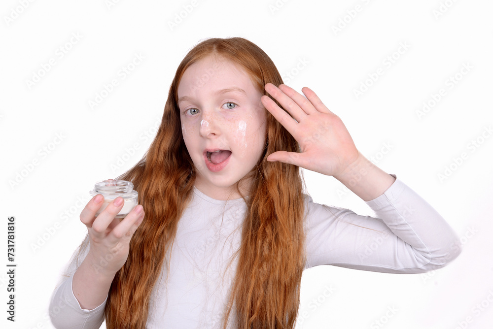 Redhead little girl with freckles uses face cream Redhead little girl with freckles uses face cream