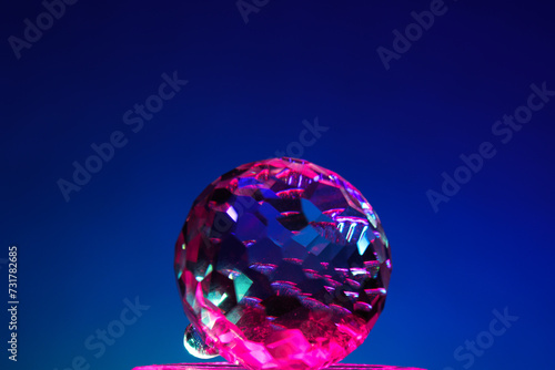 Glass ball with pink reflection on blue soft gradient background