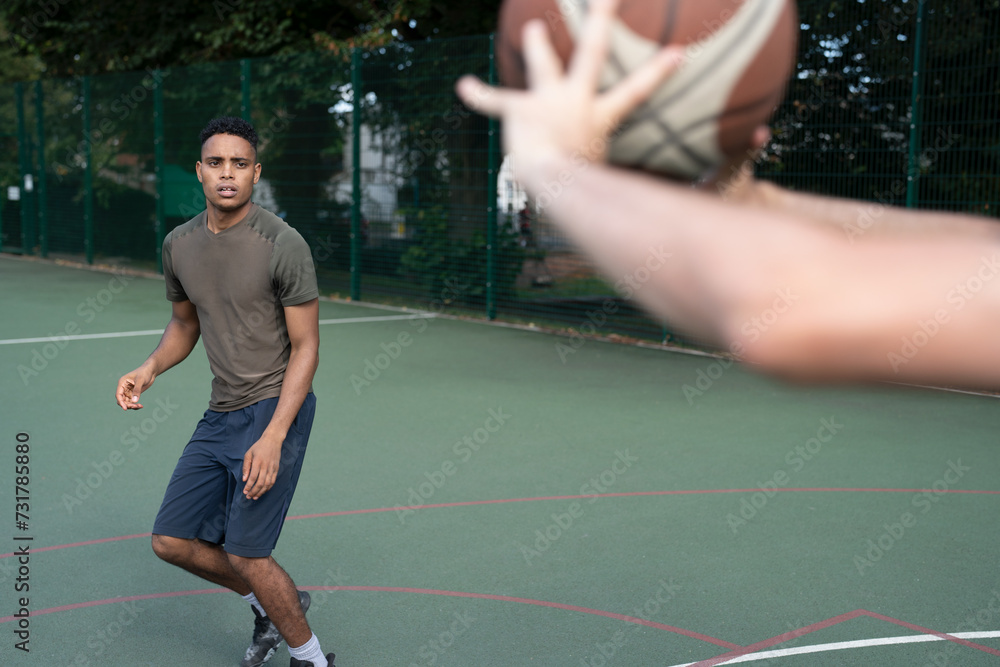 Men playing basketball outdoors