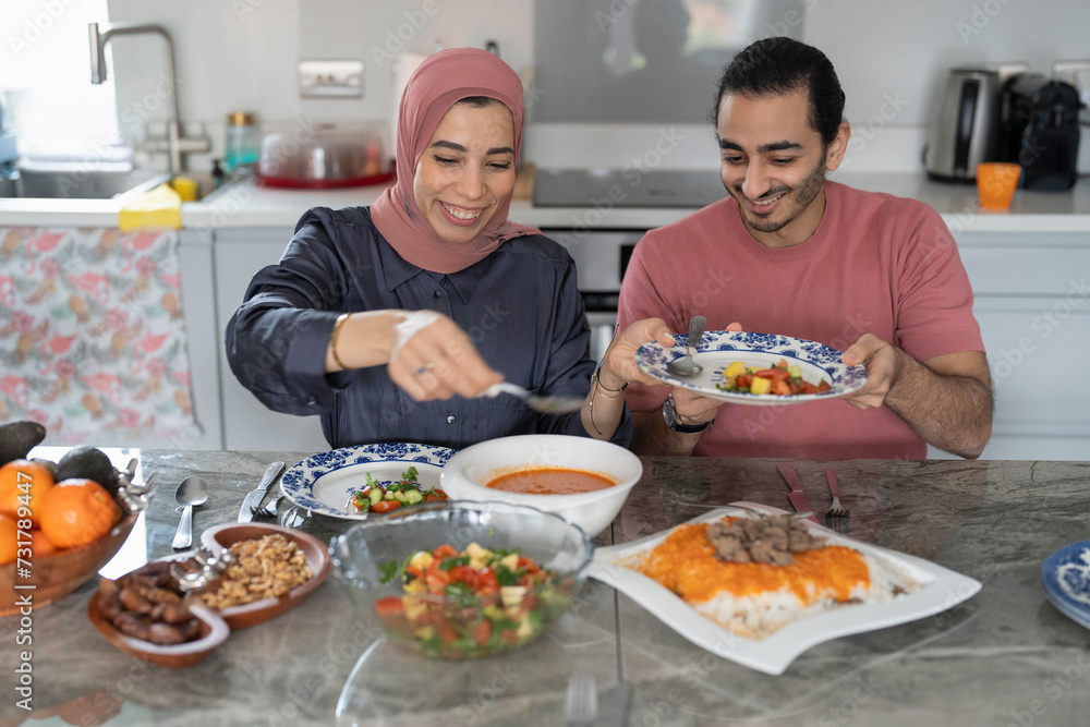 Mid adult couple eating meal at home