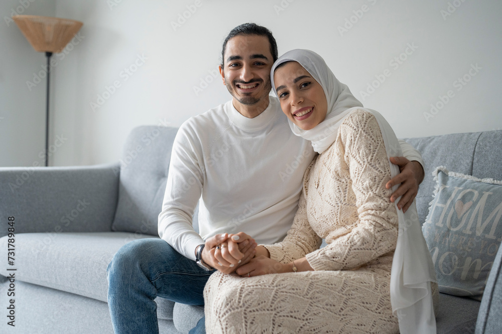 Portrait of smiling mid adult couple holding hands on sofa Portrait of smiling mid adult couple holding hands on sofa