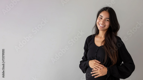 Hispanic pregnant woman with pregnancy belly, in soft black clothes © pariketan