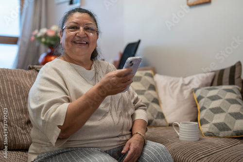 Senior woman using smart phone in living room