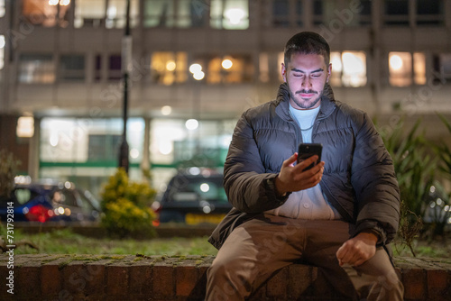 Young man using smart phone outdoors