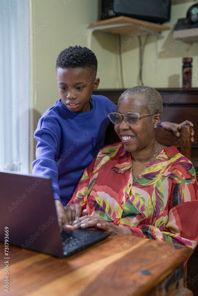 Grandmother with grandson using laptop at home Grandmother with grandson using laptop at home