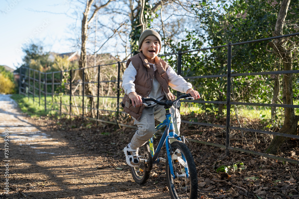 Fototapeta premium Boy (6-7) riding bike in countryside