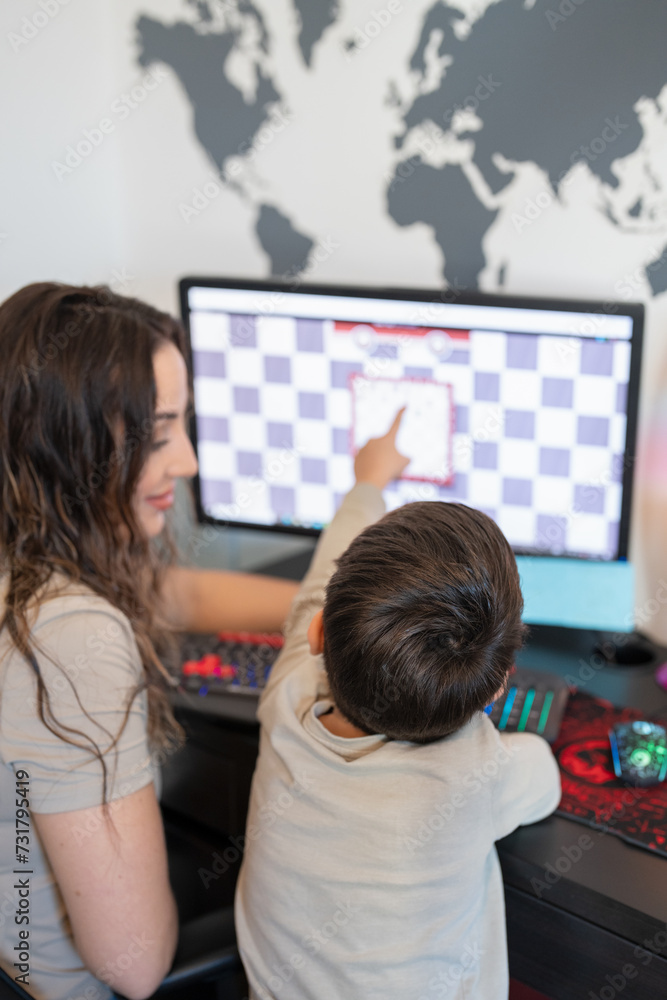 Mother and son (6-7) playing chess on computer Mother and son (6-7) playing chess on computer